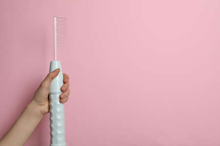 Woman with darsonval on pink background, closeup. Space for text