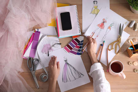 Fashion designer drawing sketch on wooden table, top viewの写真素材