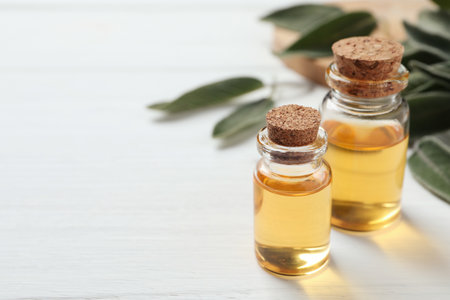Bottles of sage essential oil on white table, closeup. Space for textの写真素材