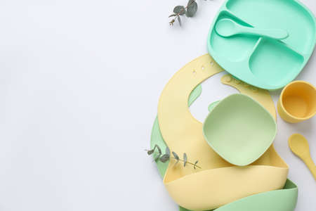 Composition with baby feeding accessories and bib on white background, top view. Space for textの写真素材