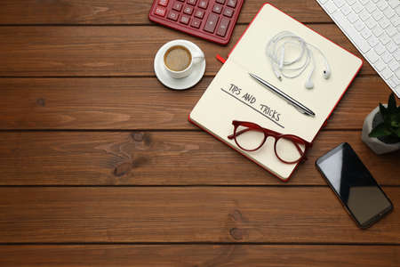 Flat lay composition with notebook on wooden table, space for text. Tips and Tricksの写真素材