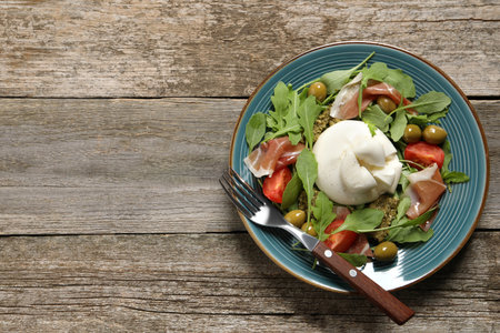 Delicious burrata salad served on wooden table, top view. Space for textの写真素材