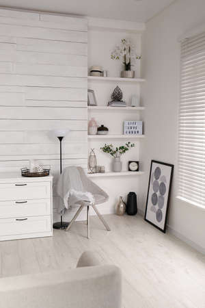 Cozy room interior with stylish furniture, wall shelves and beautiful decor elements
