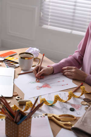 Fashion designer drawing sketch on wooden table, closeupの写真素材