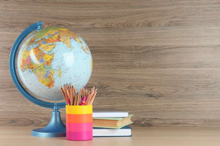 Globe, books and school supplies on wooden table, space for text. Geography lessonの写真素材