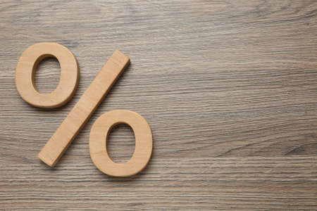 Percent sign on wooden table, flat lay. Space for textの写真素材