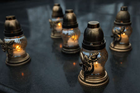 Grave lights on granite surface at cemetery