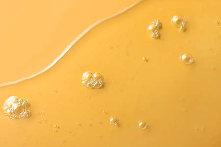Sample of hydrophilic oil on orange background, top viewの写真素材