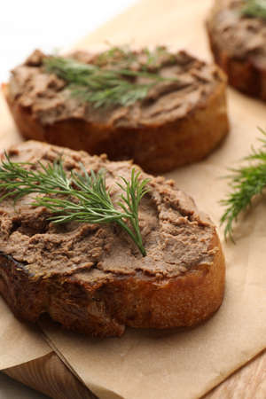 Slices of bread with delicious pate and dill on wooden board, closeupの写真素材