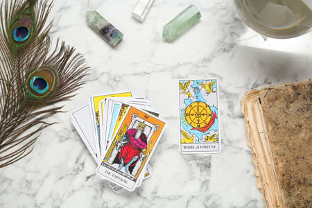 Flat lay composition with Emperor, Wheel of Fortune and other tarot cards on white marble tableの写真素材