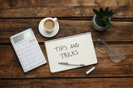 Flat lay composition with notebook on wooden table. Tips and Tricksの写真素材