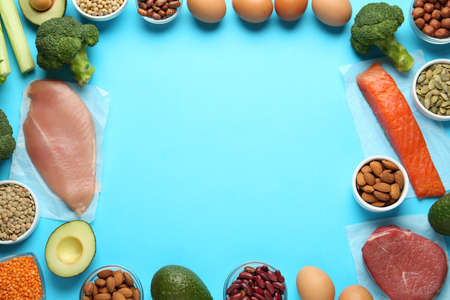 Frame of products rich in amino acids on light blue background, flat lay. Space for textの写真素材