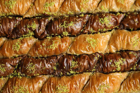 Delicious sweet baklava with pistachios as background, top viewの写真素材