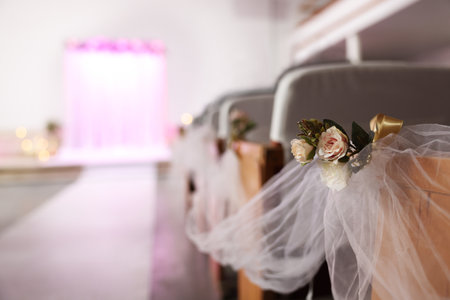 Chairs decorated with flowers and tulle indoors, closeup. wedding ceremonyの写真素材