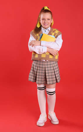 Cute indie girl with books on red backgroundの写真素材