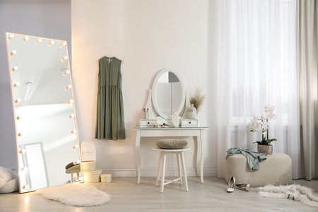 Large mirror with light bulbs and dressing table in stylish room. interior designの写真素材