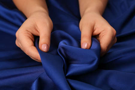 Woman touching silky blue fabric, closeup viewの写真素材