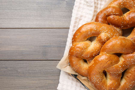 Delicious pretzels with sesame seeds on wooden table, top view. Space for textの写真素材