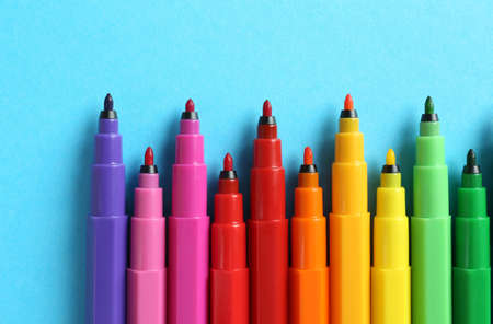 Many colorful markers on light blue background, flat lay. school stationeryの写真素材