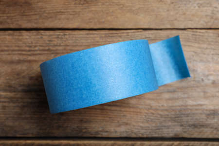 Roll of light blue adhesive tape on wooden background, top viewの写真素材