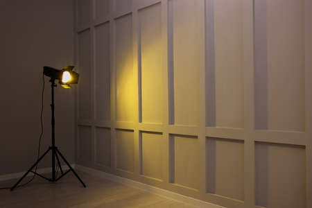 Bright yellow spotlight near wall indoors, space for textの写真素材