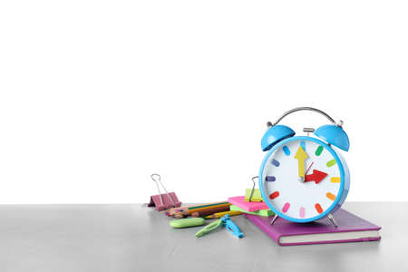 Light blue alarm clock and different stationery on wooden table against white background, space for text. school timeの写真素材