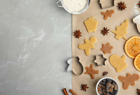 Flat lay composition with unbaked cookies and cutters on light gray marble table, space for text. christmas biscuitsの写真素材