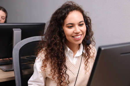 African American call center operator with headset working in modern office