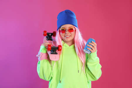 Cute indie girl with canned drink and penny board on violet background