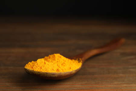Spoon with saffron powder on wooden tableの写真素材