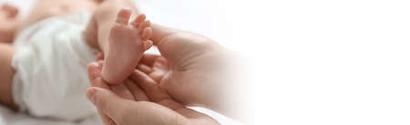 Mother massaging her cute baby with oil, closeup. Banner design with space for textの写真素材