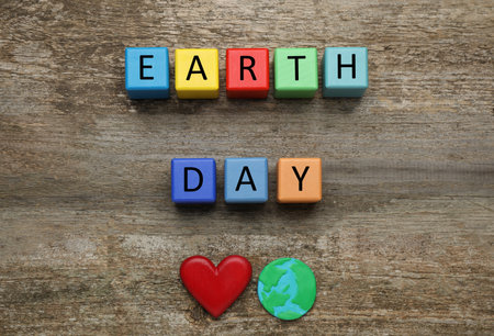 Colorful cubes with words Earth Day, decorative heart and plastic planet on wooden table, flat layの写真素材
