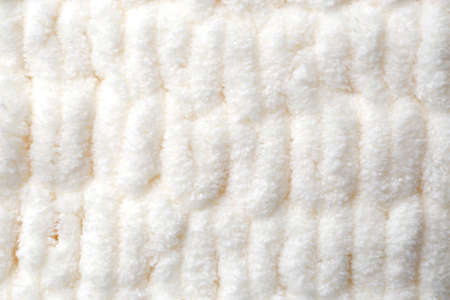 Soft white knitted fabric as background, top view