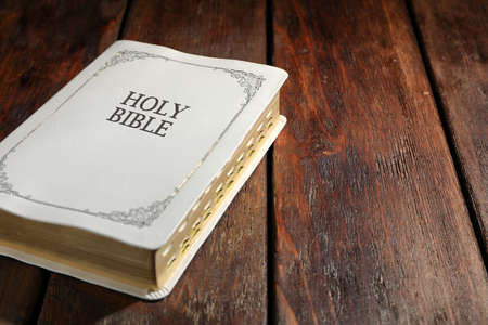 Old hardcover Bible on wooden table, space for text. religious book