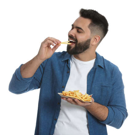 Young man eating french fries on white backgroundの写真素材