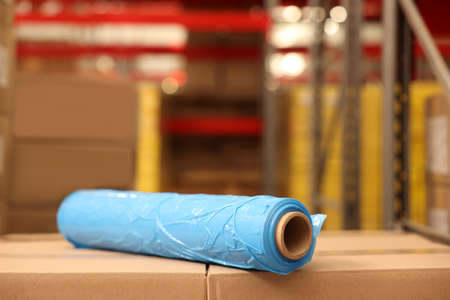 Roll of stretch wrap on boxes in warehouseの写真素材