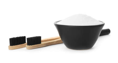 Bamboo toothbrushes and bowl with baking soda on white backgroundの写真素材