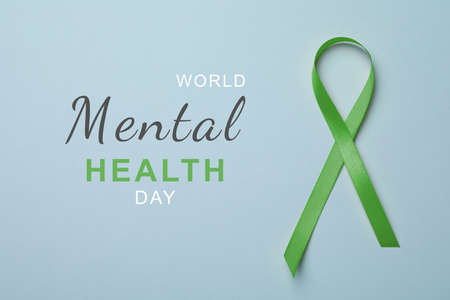 World Mental Health Day. Green ribbon on light blue background, top viewの写真素材