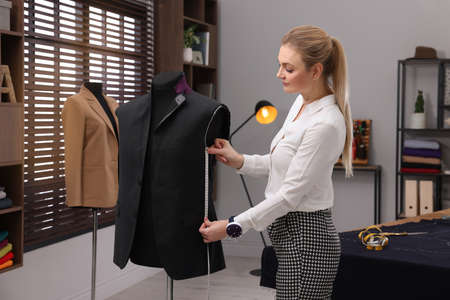 Dressmaker with measuring tape working in atelierの写真素材