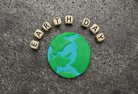 Cubes with words Earth Day and plastic planet on gray table, flat layの写真素材
