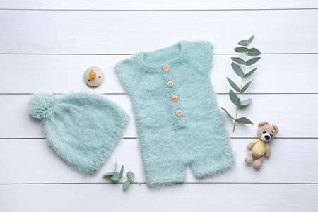 Flat lay composition with child's clothes and accessories on white wooden table