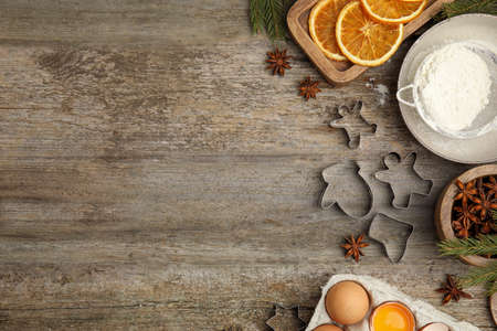 Flat lay composition with cookie cutters and ingredients on wooden table, space for text. christmas biscuitsの写真素材