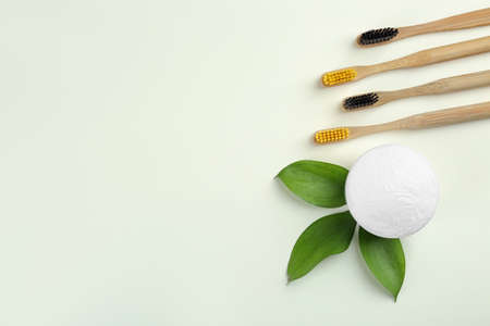 Bamboo toothbrushes and bowl of baking soda on beige background, flat lay. Space for textの写真素材