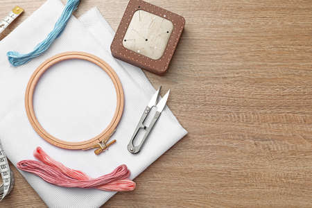Set of embroidery equipment on wooden table, flat lay. Space for textの写真素材