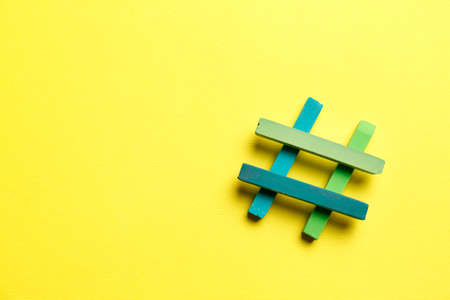 Hashtag symbol made of colorful chalks on yellow background, top view. Space for textの写真素材