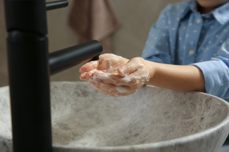Little girl washing hands with liquid soap in bathroom, closeupの写真素材