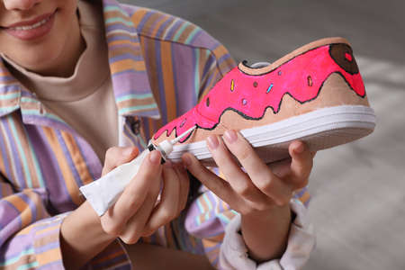 Woman painting on sneaker indoors, closeup. custom shoesの写真素材