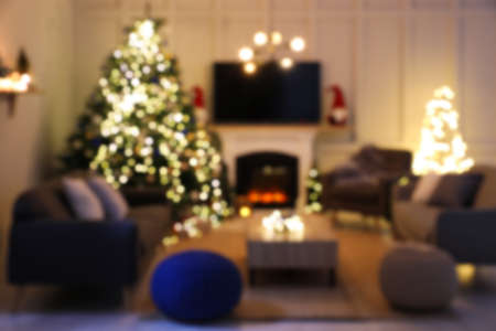 Blurred view of room with beautiful Christmas tree near fireplaceの写真素材