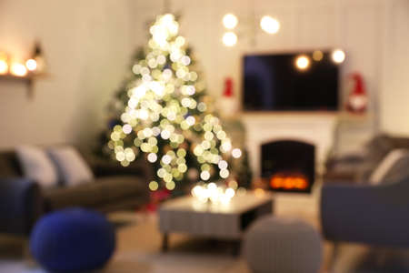 Blurred view of room with beautiful Christmas tree near fireplaceの写真素材