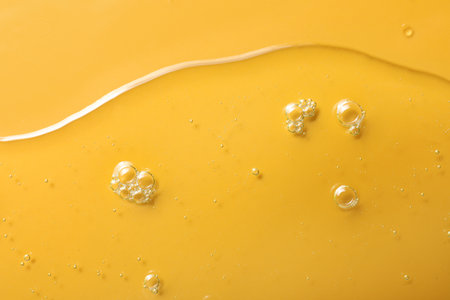 Sample of hydrophilic oil on orange background, top viewの写真素材